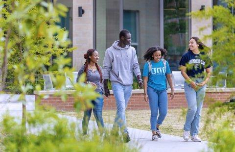 A group of students walking in front of Owens House residence hall